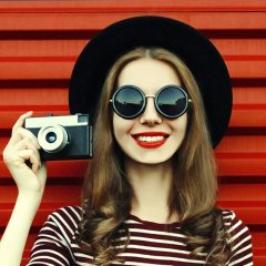 Portrait close up of smiling woman photographer with vintage fil
