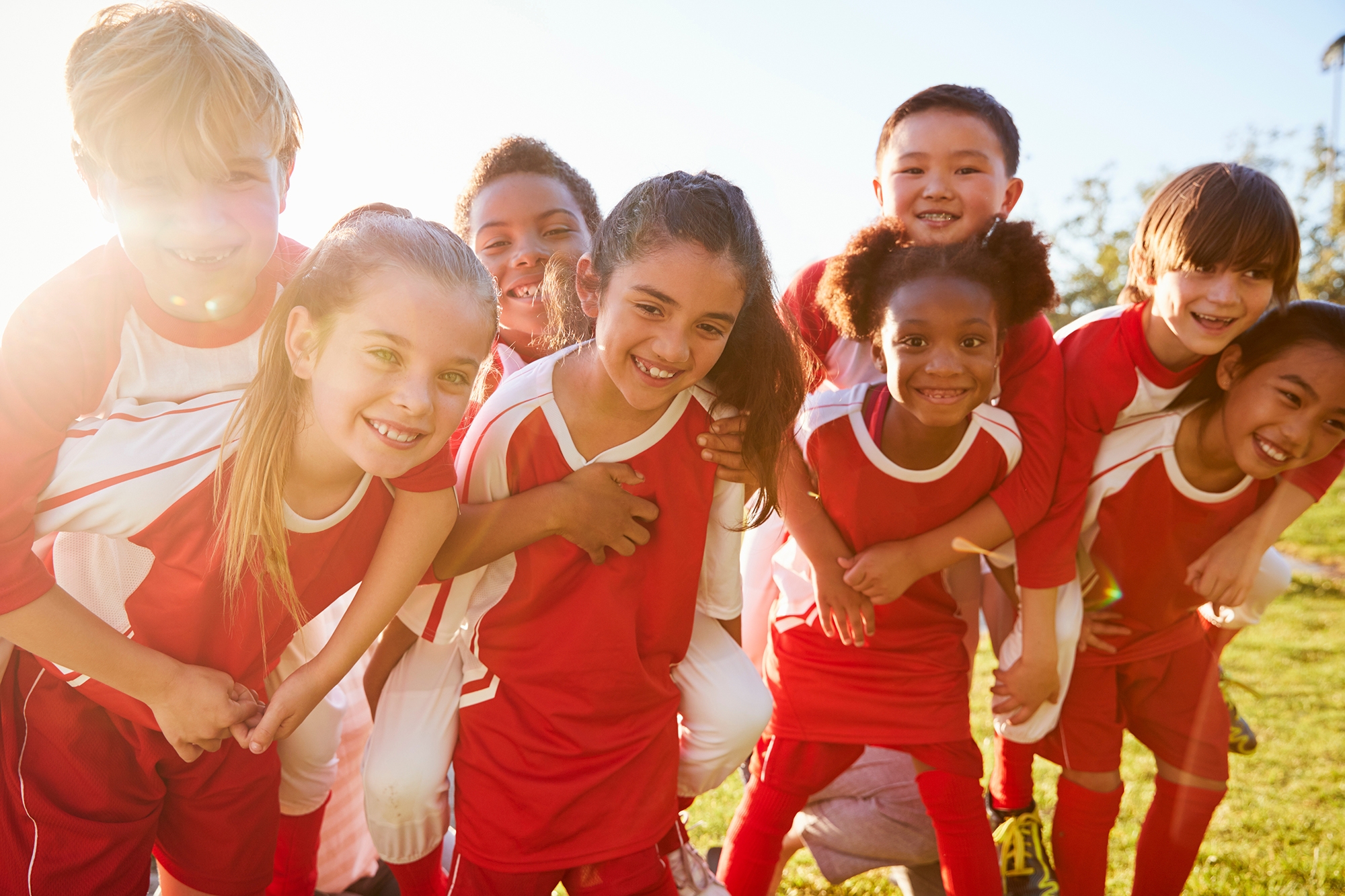 Les enfants de l'école primaire de l'équipe de sport piggybacking en plein air